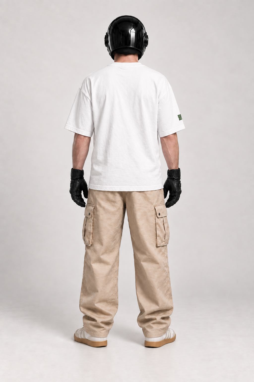 Rear view of SVO wearing the white ISSUE #1 SKULL oversized T-shirt, showing its relaxed fit with dark trousers.