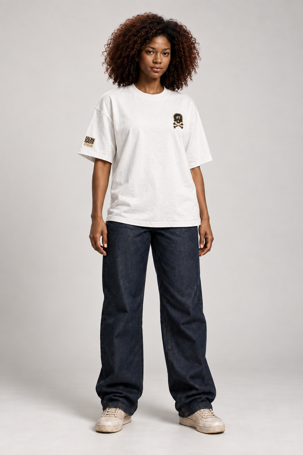 Front view of a Dawn wearing the white ISSUE #1 SKULL oversized T-shirt with dark loose-fitting trousers.